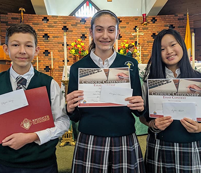 The winner of the K of C Catholic citizenship essay contest holding the award.