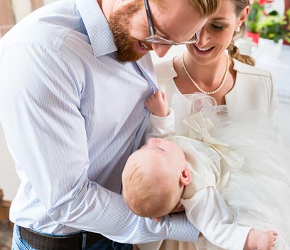 Parents holding their infant during Baptism