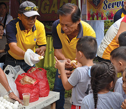 Knights in the Philippines distributing food to children