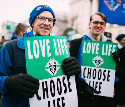 Two young Knights holding posters during the March for Life event in Washington D.C.