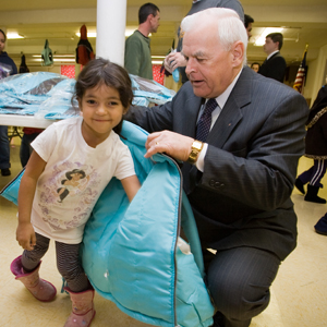 Deputy Supreme Knight Dennis Savoie assists a student from St. Francis and St. Rose of Lima School