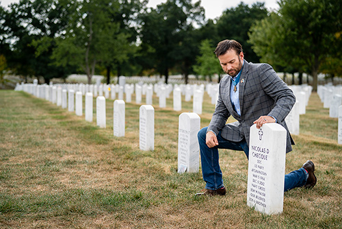 Medal of Honor recipient Edward Byers Jr. prays at the grave of his Navy SEAL teammate Nicolas Checque in Arlington National Cemetery. Checque was killed during a rescue mission in Afghanistan.
