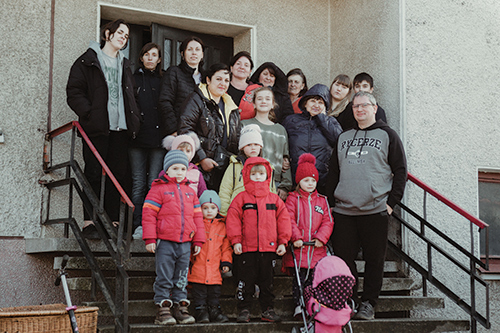 Adam Weigel-Milleret (right) stands together with some of the refugees he and his wife have welcomed and housed in a large residence next to his company headquarters in Igołomia, Poland. Photo by Sebastian Nycz