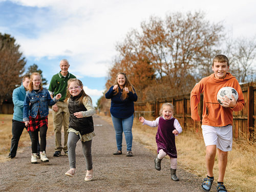 Jeff and Sonia McGarrity take a stroll with five of their eight children outside their home near Lone Tree, Colo. (Photo by Ryan Dearth)