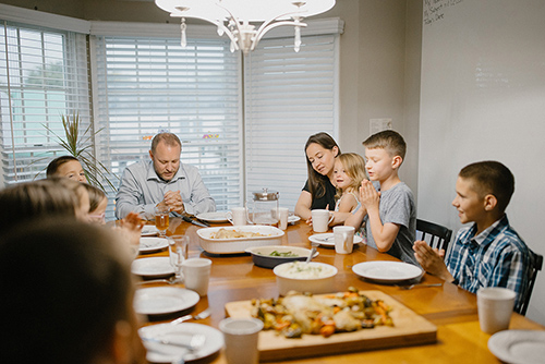 The Hermosillo family prays before a meal at their home in Frederick, Md.