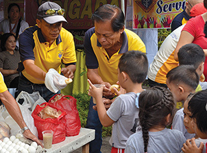 Knights in the Philippines distributing food to children