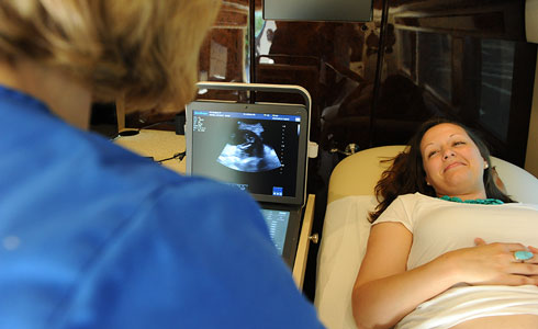 A young mother is in the process of receiving an ultrasound scan.