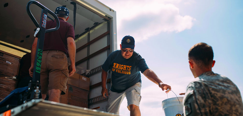 Knights unloading supplies for distribution in an effort for disaster relief.  