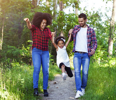 Young daughter swings holding the hands of her parents