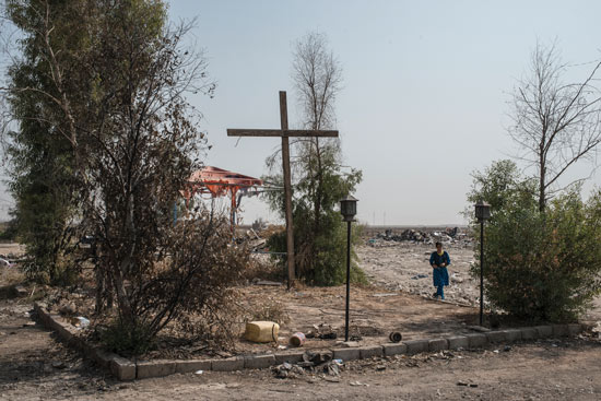 A newly erected cross stands in a Karamles plaza