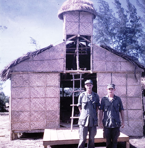 Father Capodanno stands with a marine near makeshift chapel
