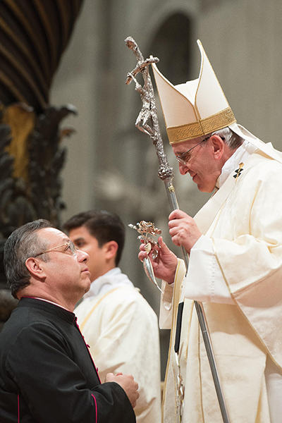 Pope Francis receives the silver rose from a man