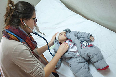 Dr. Dudová takes the heartbeat of a young baby at the clinic